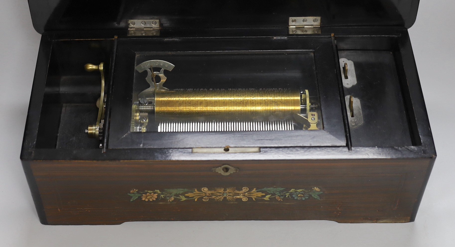 A late 19th century Swiss rosewood and marquetry cased cylinder music box, playing six airs, lacking tune sheet, 43cms wide x 14cms high